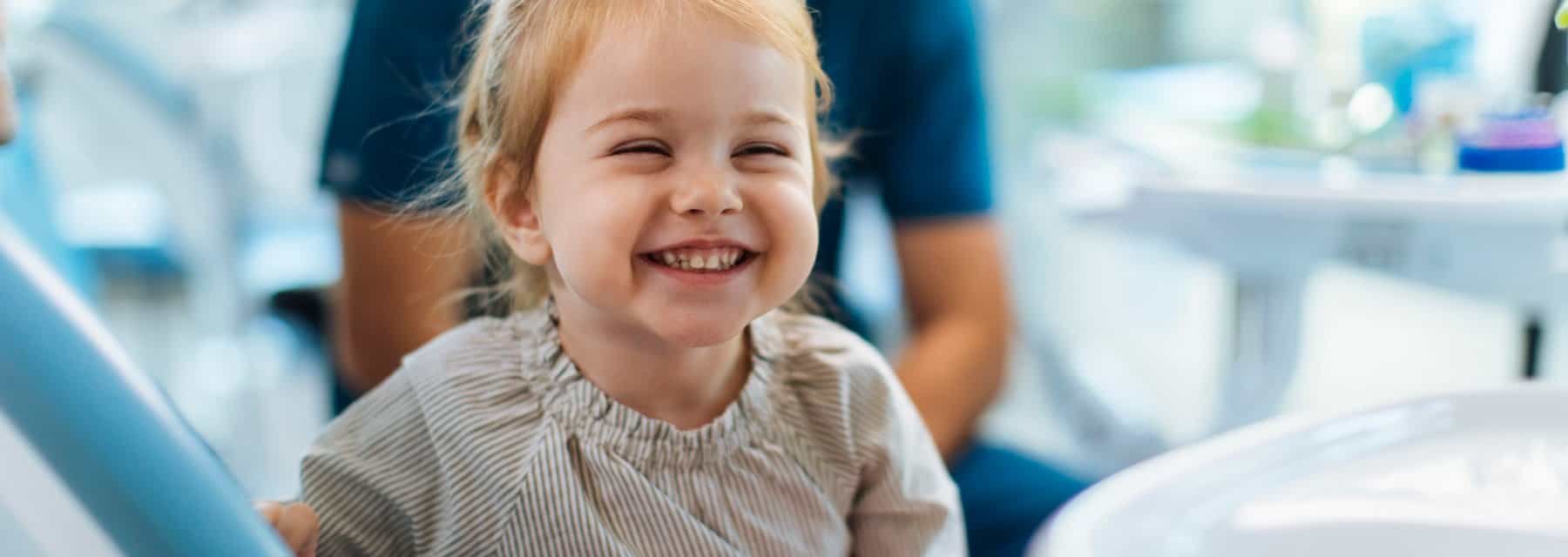 A joyful girl in a dentist's chair smiles brightly while receiving dental care at, Washington