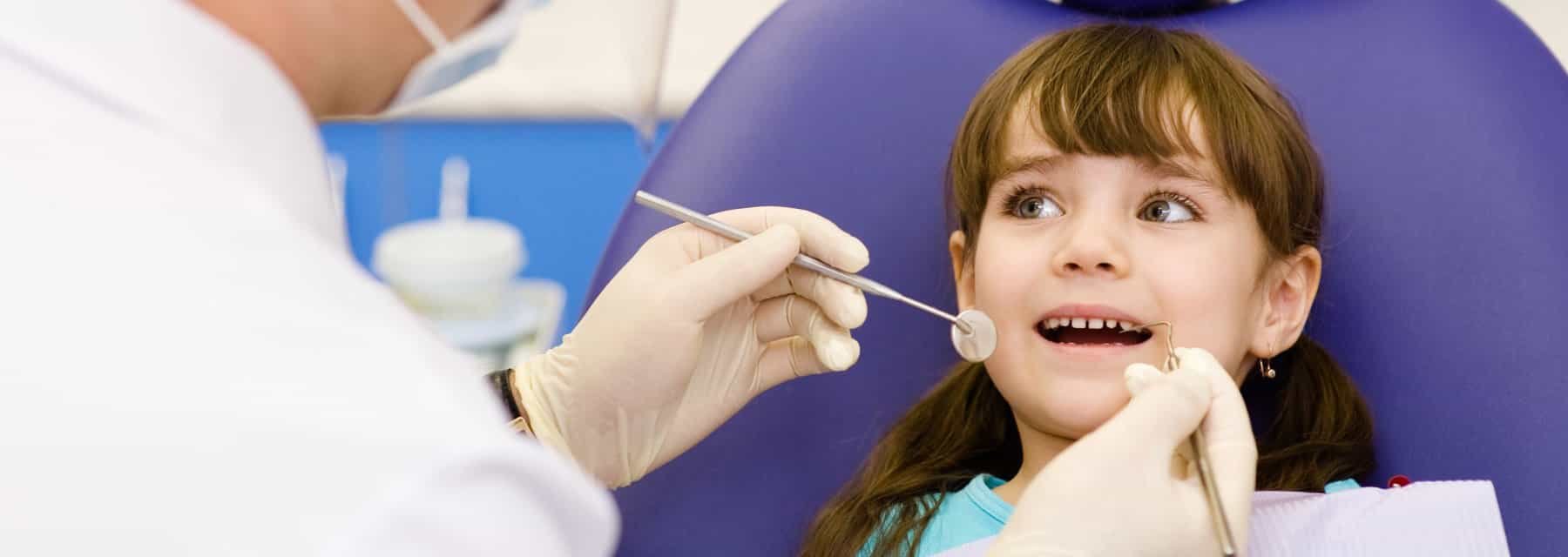 A woman inspects a child's teeth in a bright of Spokane Valley Washington