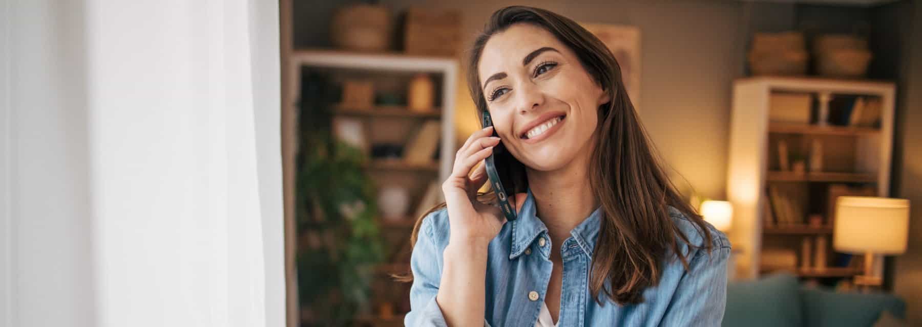 A woman smiling while engaged in a phone conversation, Spokane Valley Washington